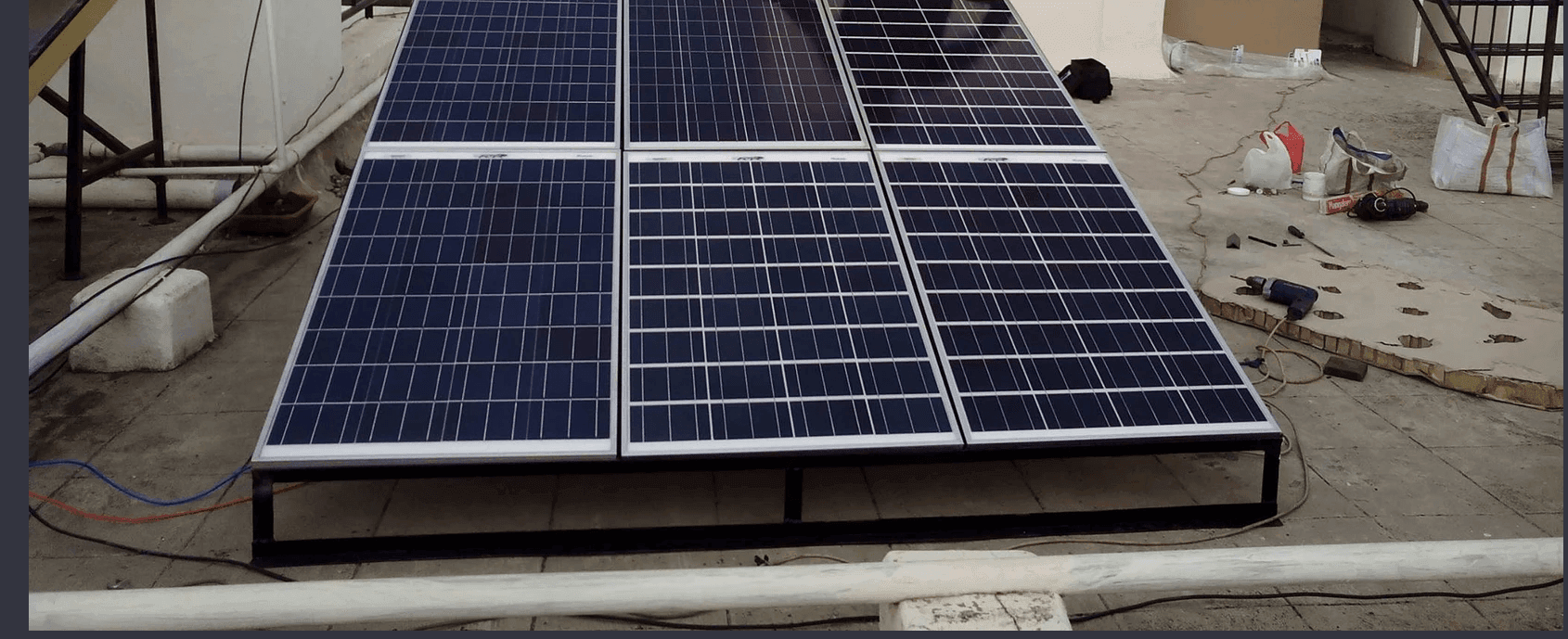 Large solar panels installed on a rooftop, with various tools and equipment scattered around.